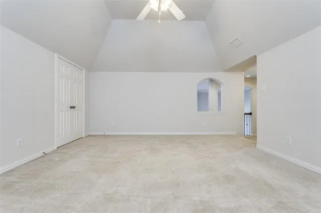 an empty room with a chandelier fan