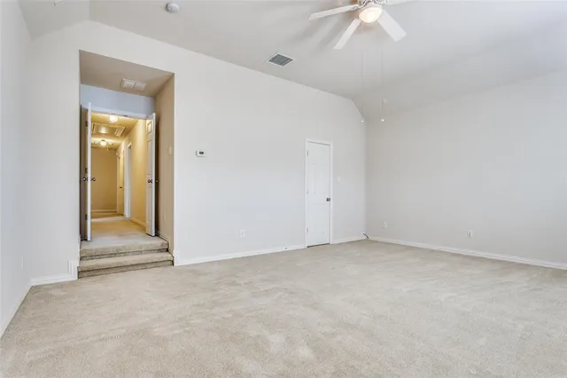 an empty room with a ceiling fan and a window