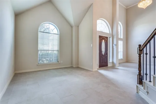 an empty room with a fireplace and windows
