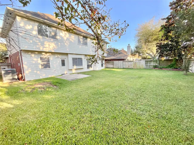 a view of a big house with a big yard and large trees