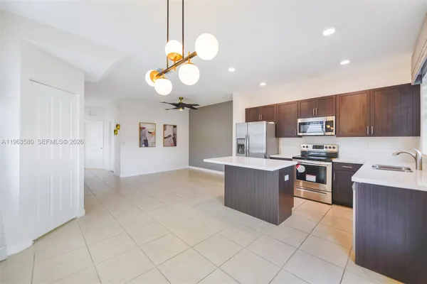 a large kitchen with a large counter top cabinets and stainless steel appliances