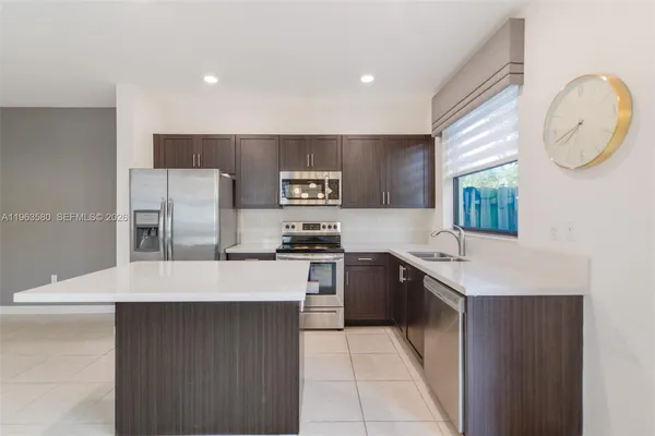 a kitchen with stainless steel appliances granite countertop a refrigerator and a stove