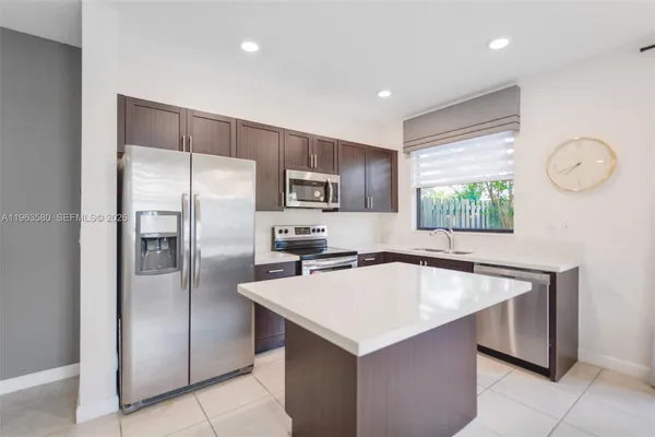 a kitchen with a refrigerator a sink dishwasher and a stove with wooden floor