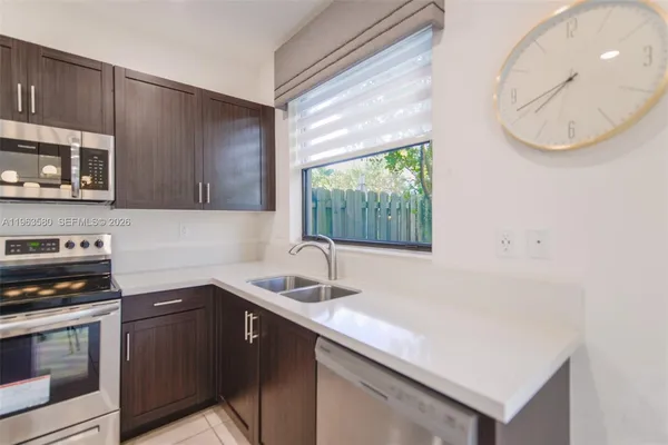 a kitchen with a sink a microwave and cabinets