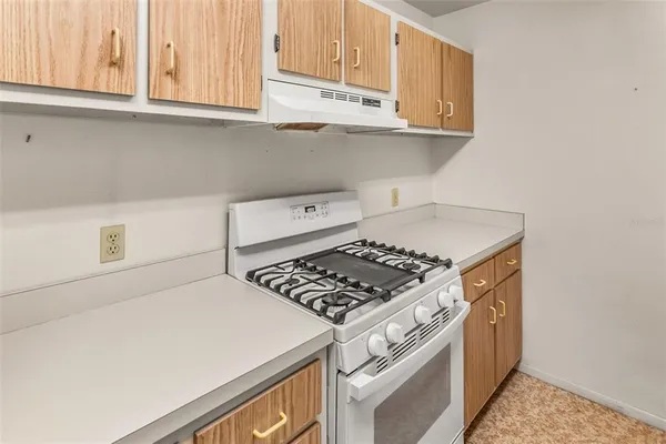a kitchen with granite countertop a stove and a white cabinets
