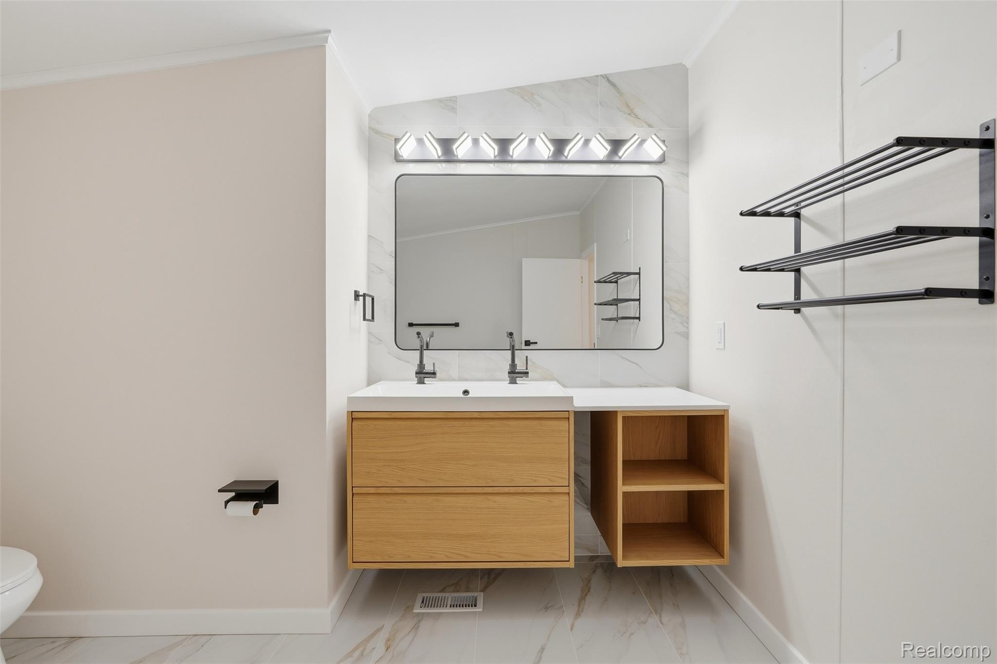 4420 Dublin Road Burton, MI 48529 - Photo 19 of 56 Modern vanity featuring a wood-finish double-drawer base with open shelving, a rectangular sink, and a black-framed mirror