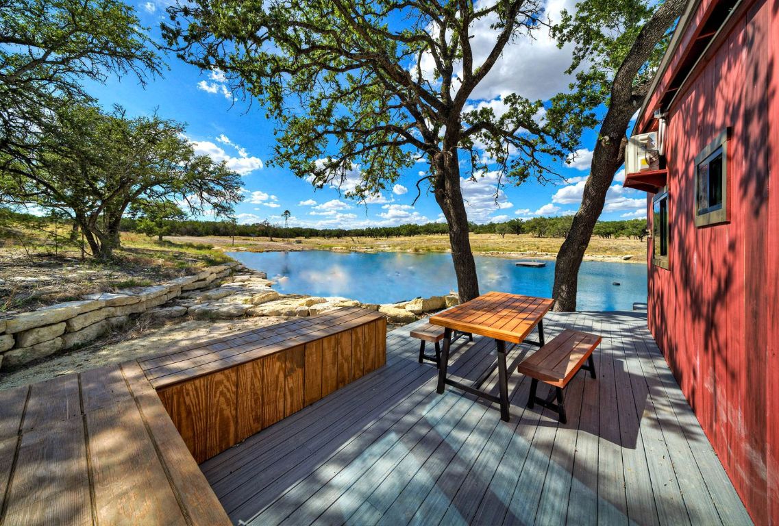 0 Gibson-Best Road Hye, TX 78635 - Photo 28 of 40 a roof deck with table and chairs under an umbrella