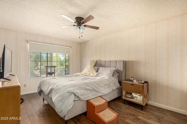 a bed sitting in a spacious bedroom next to a window