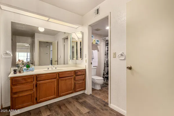 a spacious bathroom with a double vanity sink a toilet and a shower