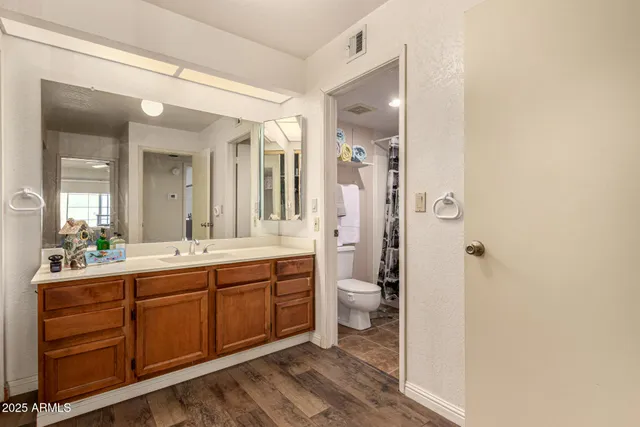 a spacious bathroom with a double vanity sink a toilet and a shower