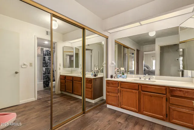 a large bathroom with a double vanity sink and mirror with shower