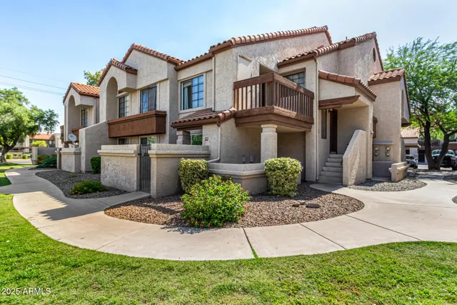 a front view of a house with a yard and potted plants