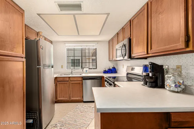 a kitchen with stainless steel appliances granite countertop a sink refrigerator and cabinets