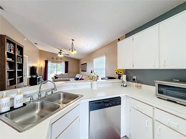 a kitchen with a sink a stove and cabinets