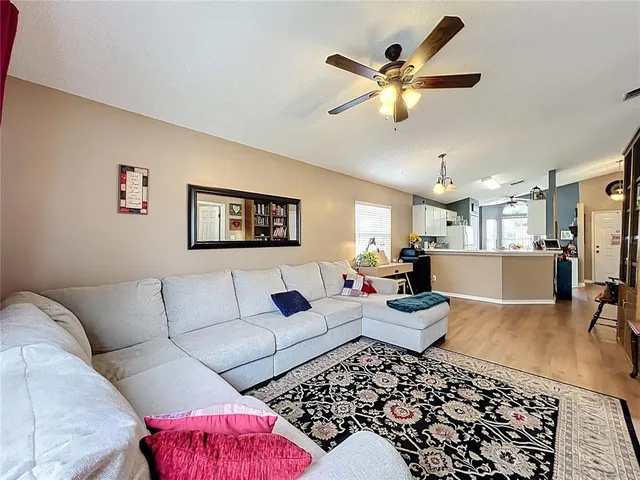 a living room with furniture and view of kitchen