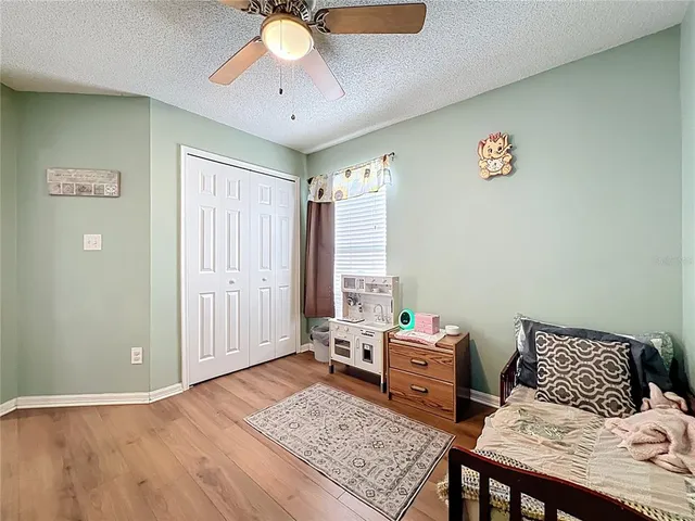 a bedroom with a bed and wooden floor