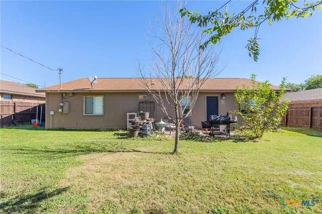 a view of a house with backyard and sitting area