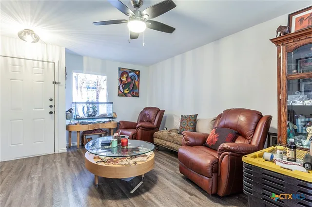 a living room with furniture a bookshelf and a window
