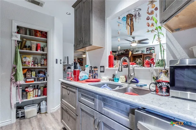 a kitchen with kitchen island stainless steel appliances a sink and a refrigerator