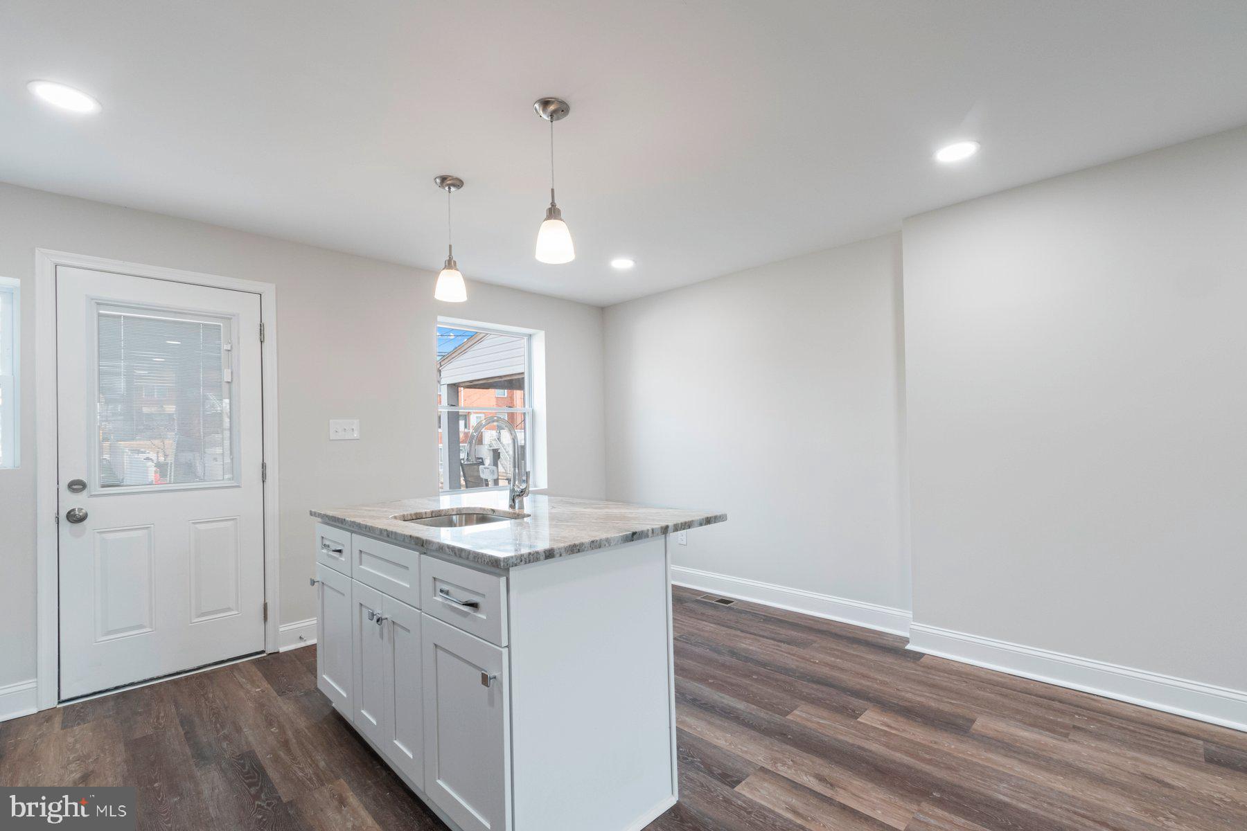 7324 Kirtley Road Baltimore, MD 21224 - Photo 8 of 27 a kitchen with a sink window and wooden floor