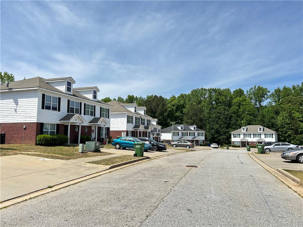 630 Mill Stone Bluff, Unit B Monroe, GA 30655 - Photo 12 of 14 a view of road with card parked on side and retail shops