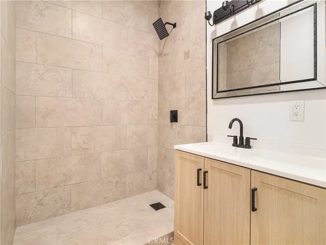 a bathroom with a shower sink and mirror