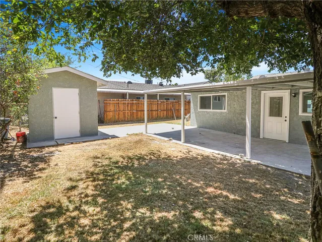 a backyard of a house with yard and large tree