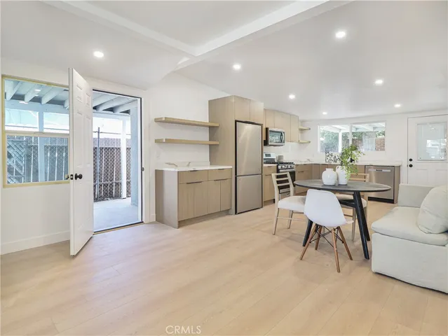 a living room with kitchen island furniture and a refrigerator