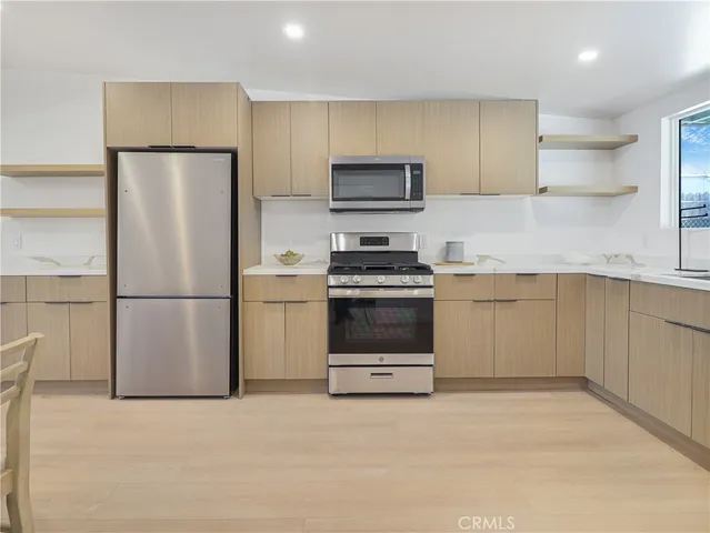 a kitchen with stainless steel appliances a refrigerator sink and cabinets