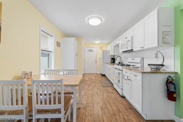 a kitchen with granite countertop a sink cabinets stainless steel appliances and a window