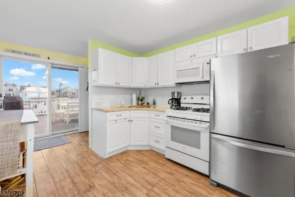 a kitchen with stainless steel appliances white cabinets and a refrigerator