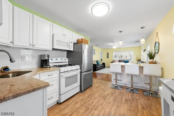 a kitchen with stainless steel appliances granite countertop a stove a sink dishwasher and a refrigerator