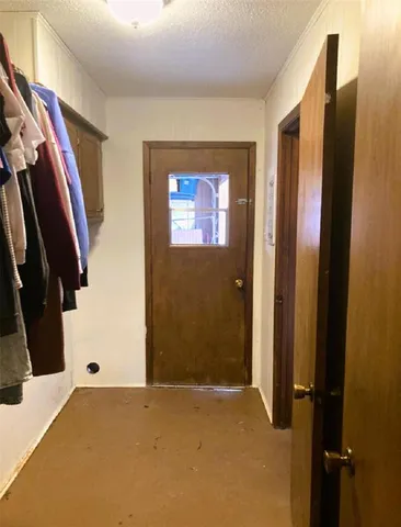a view of a hallway with closet and front door
