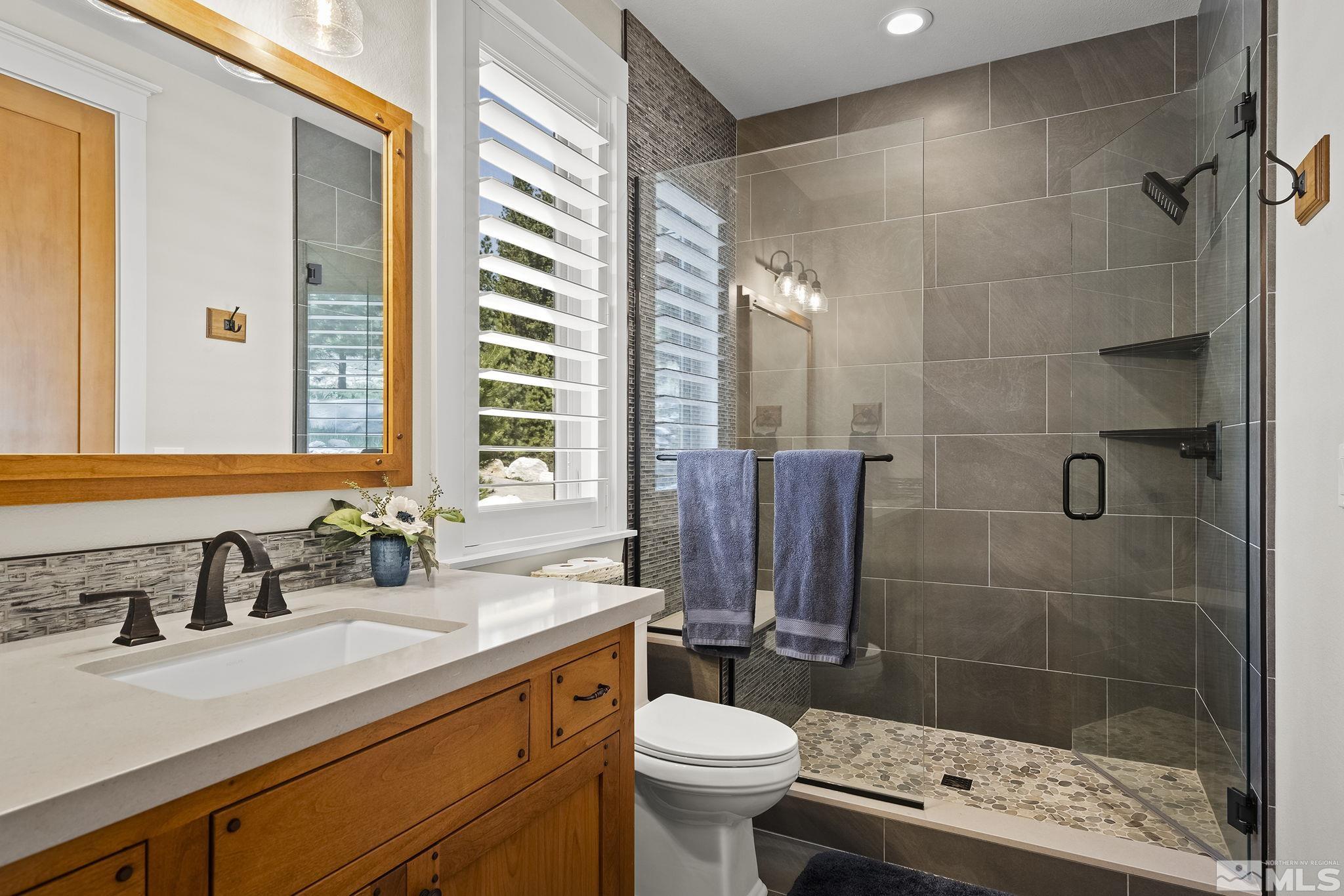 119 Five Creek Road Gardnerville, NV 89460 - Photo 30 of 40 a bathroom with a sink a toilet a mirror and shower
