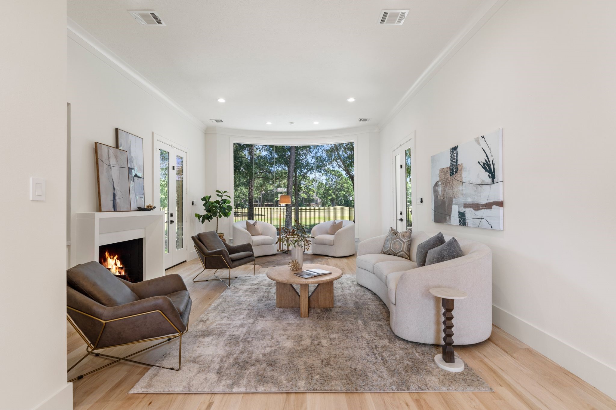31 Hollymead Drive Spring, TX 77381 - Photo 12 of 50 The formal living room offers an elegant atmosphere with a modern stone gas log fireplace, and seamless large window providing a beautiful view of the wooded backyard and the golf course.