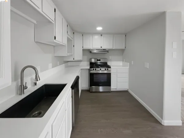 a kitchen with granite countertop a stove and a refrigerator