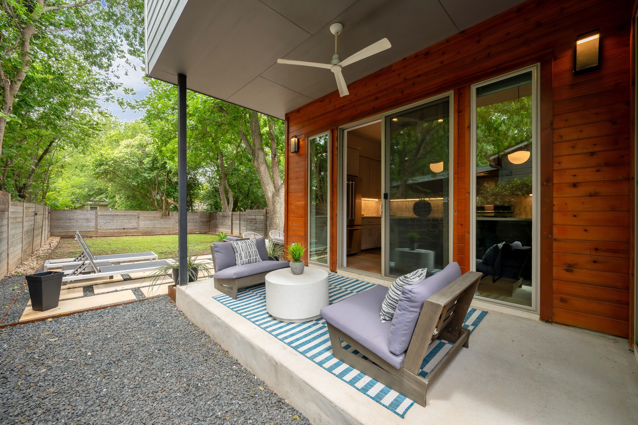 1409 Alegria Road, Unit A Austin, TX 78757 - Photo 20 of 24 An inviting outdoor patio, framed by lush trees, offers serene relaxation and direct access to the interior.