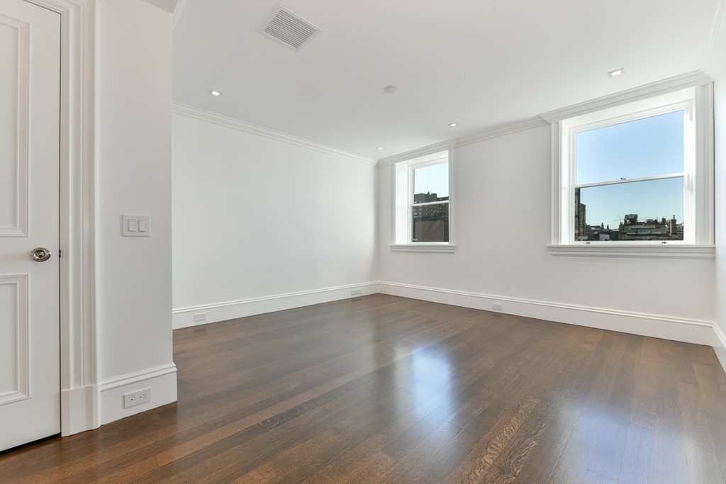 35 Commonwealth Avenue, Unit PH Boston, MA 02116 - Photo 19 of 25 an empty room with wooden floor and windows