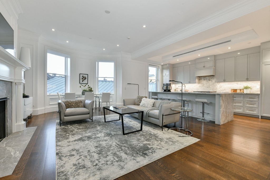 35 Commonwealth Avenue, Unit PH Boston, MA 02116 - Photo 9 of 25 a living room with couches and kitchen view with wooden floor