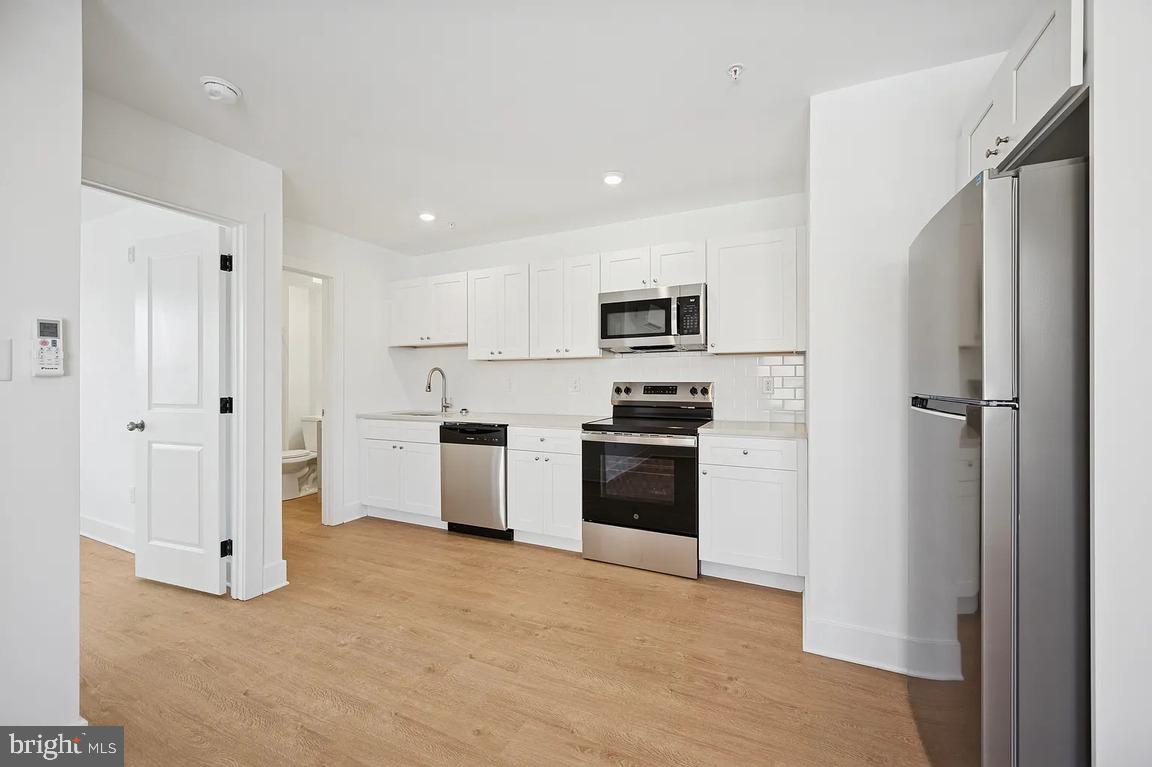 3413 North 19th Street, Unit 2F Philadelphia, PA 19140 - Photo 11 of 24 a kitchen with white cabinets and stainless steel appliances