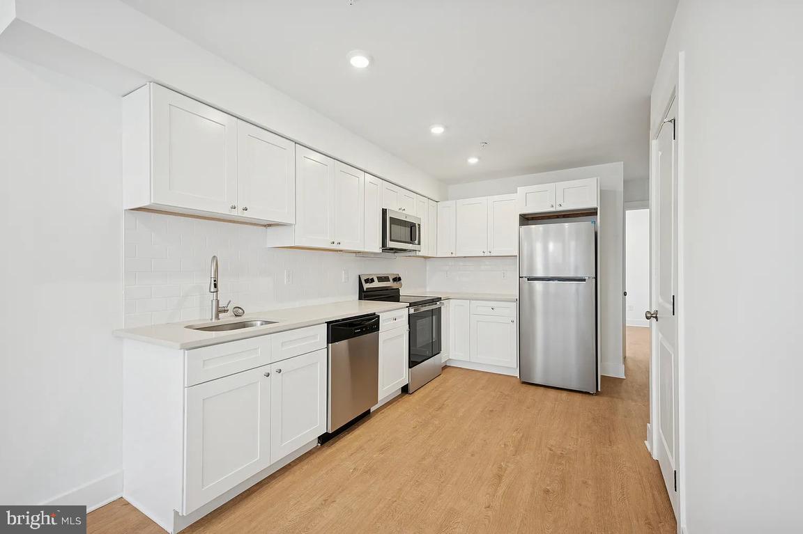 3413 North 19th Street, Unit 2F Philadelphia, PA 19140 - Photo 21 of 24 a kitchen with white cabinets and white appliances