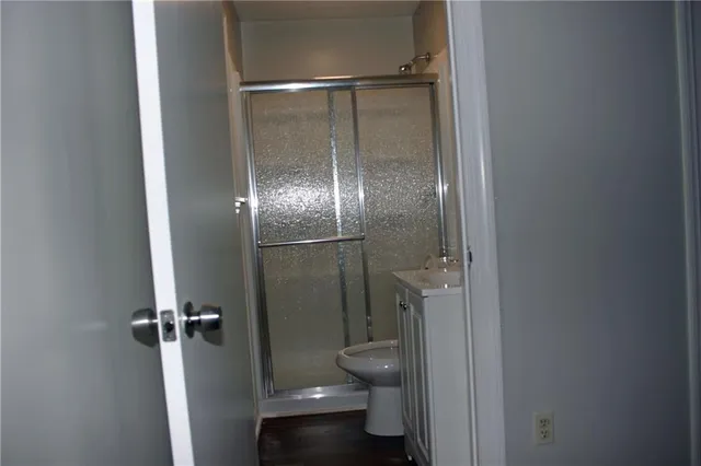 a bathroom with a granite countertop toilet and a glass door