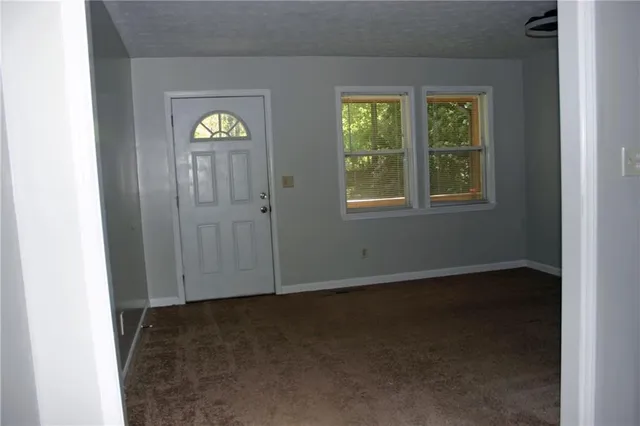 an empty room with windows closet and mirror