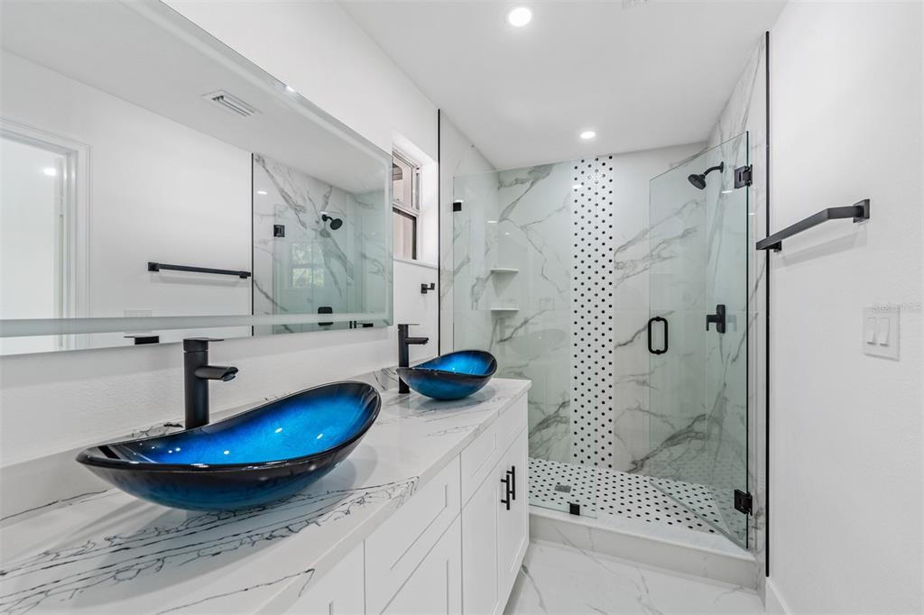 1413 May Street Lutz, FL 33548 - Photo 14 of 21 a bathroom with a sink a shower and a mirror