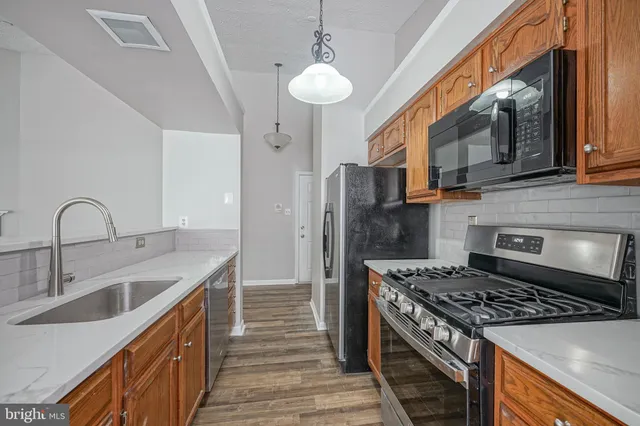 a kitchen with stainless steel appliances granite countertop a stove and a sink