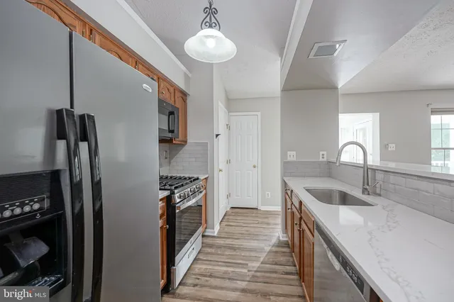 a kitchen with stainless steel appliances granite countertop a sink and a refrigerator
