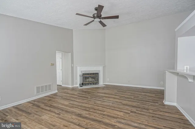 a view of empty room with wooden floor and fireplace