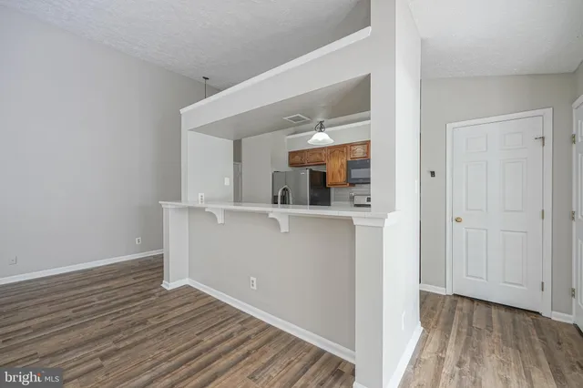 a view of a hallway with wooden floor and a living room