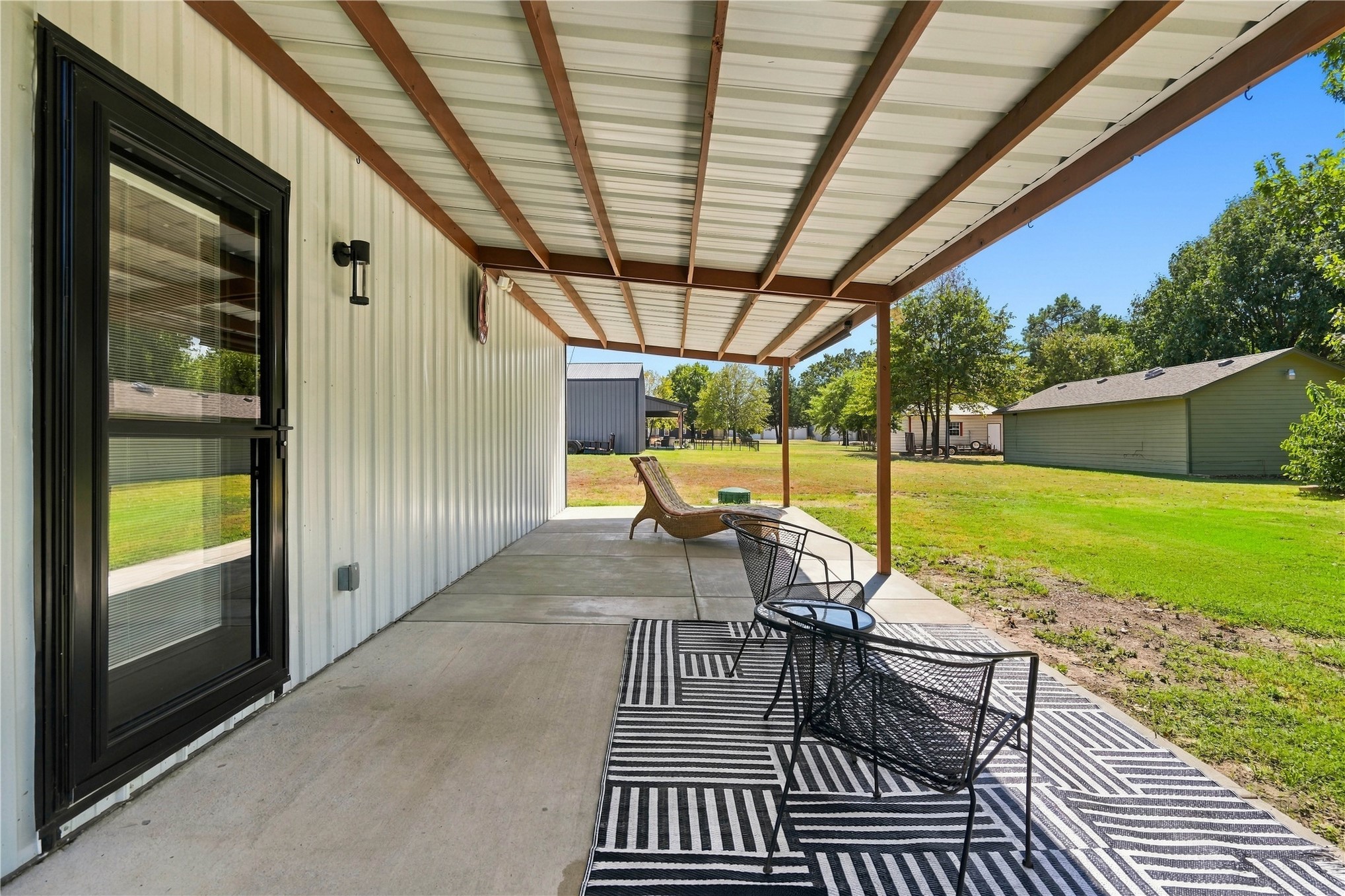 420942 East 1168 Road Eufaula, OK 74432 - Photo 9 of 43 Covered concrete patio with a corrugated metal roof and exposed wood beams