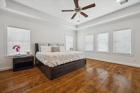 a bedroom with a large bed and wooden floor